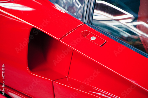 close-up of door handle with keyhole of red modern car © Nana_studio