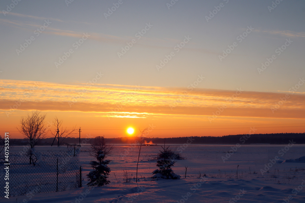 Sunrise over a winter field, early morning, rustic landscape