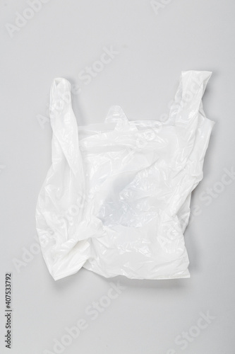 Clear disposable plastic bag on grey background. Space for text