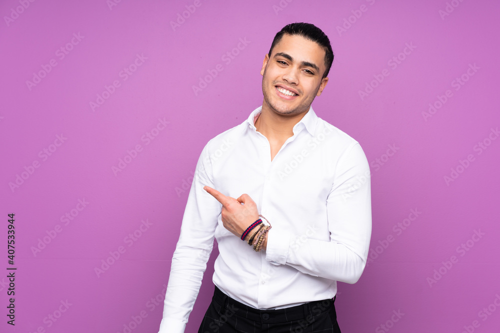 Asian handsome man isolated on blue background pointing to the side to present a product