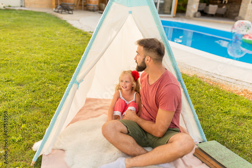 Father hugging his daughter while camping in the backyard