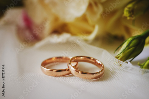 gold rings and a beautiful bridal bouquet of roses on the background. details, wedding traditions. close-up, macro