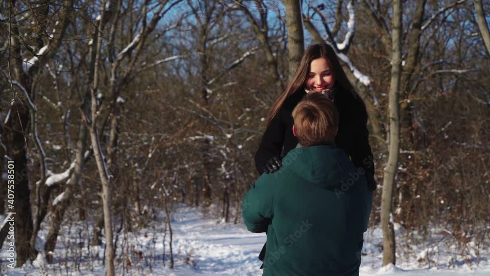 Happy Couple Having Fun in Winter Forest, Playing in Snow. Cheerful Man in Love Holds His Girlfriend in His Hands. Lovers, Positive Emotions and Family. Valentine's Day. Slow motion. Happy Couple Having Fun in Winter Forest, Playing in Snow. Cheerful Man in Love Holds His Girlfriend in His Hands. Lovers, Positive Emotions and Family. Valentine's Day. Slow motion.