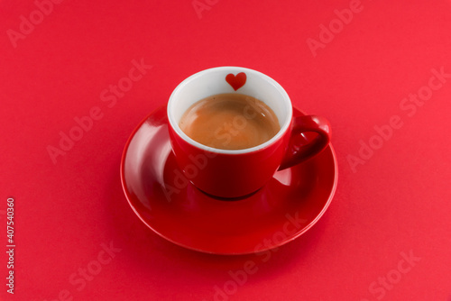 red cup of coffee espresso with little heart on a red background