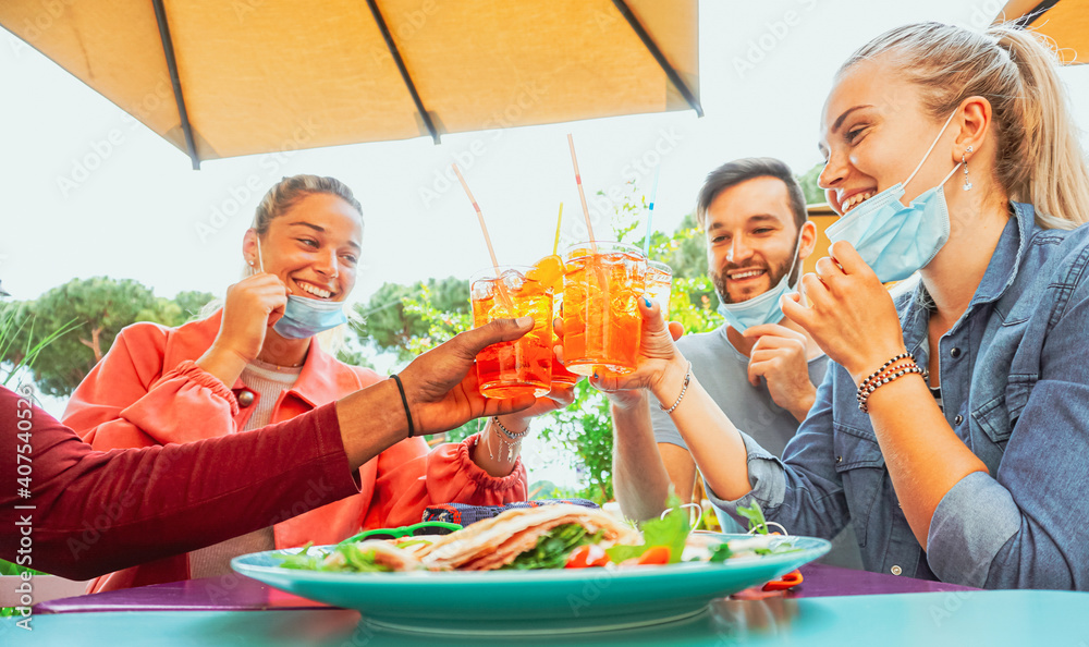 Friends drinking coktail and eating snack tapas in a restaurant bar outside in summer days with