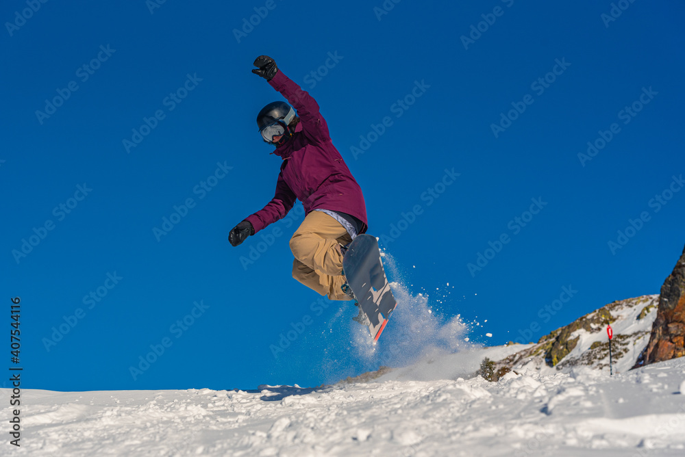 Young woman snowboarder in motion on snowboard in mountains Young woman snowboarder in motion on snowboard in mountains