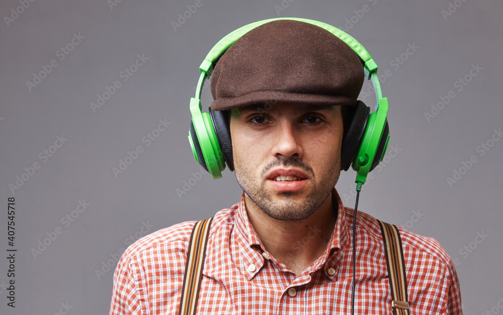 Fototapeta premium Retro music. Portrait of handsome male dj in fashionable retro styled wear and headphones. Party, music, relax concept.