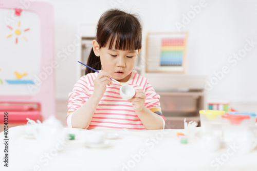 young girl decorating hand made craft for homeschooling