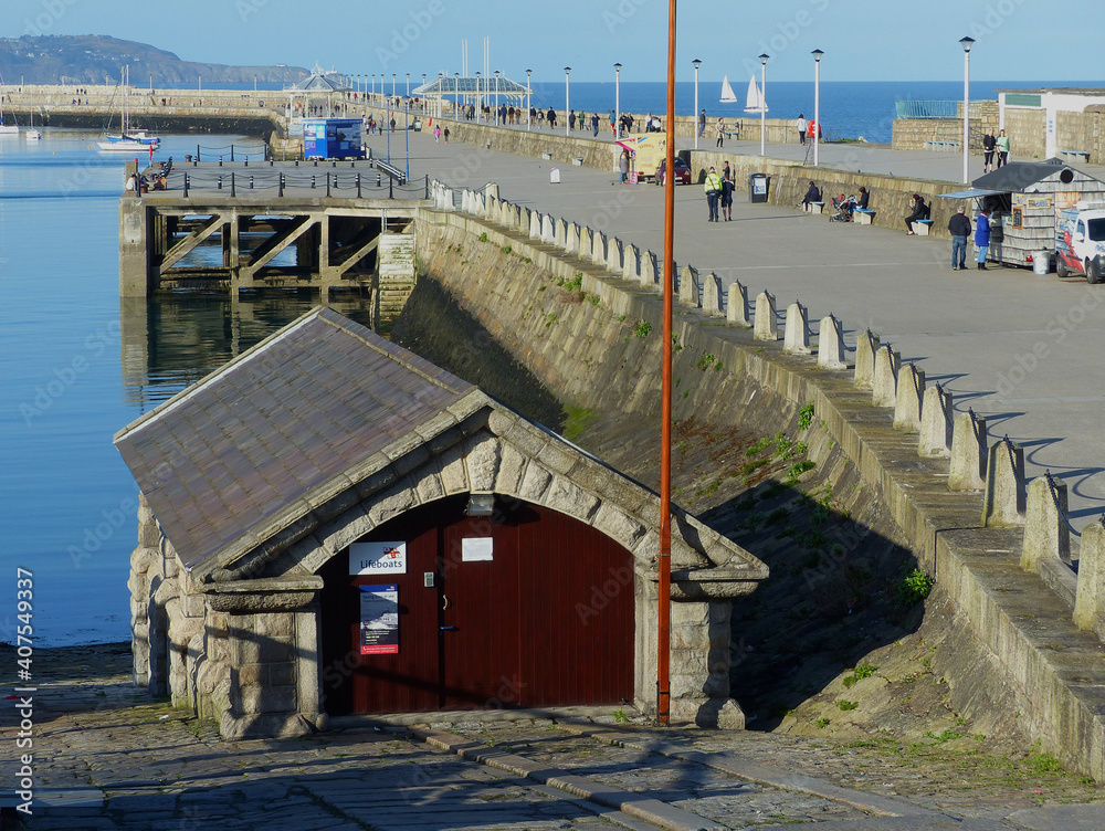 On 5 May 2016 The famous Victorian East Pier in Dunloaghaire Ireland with the stone built  boat house provides with visitors enjoying the sunshine on a spring morning. 