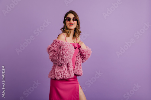 Joyful woman posing in trendy pink dress. Photo of blithesome lady wears fluffy jacket.