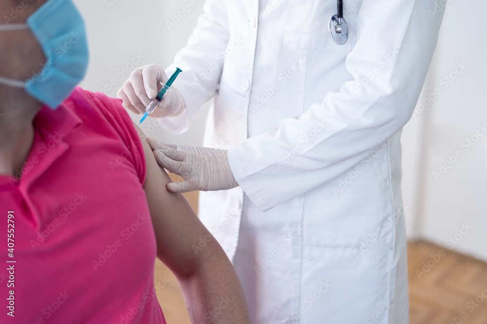 Young Female doctor in protective mask injecting or prepairing for injecting vaccine against coronavirus or ncov 19 or covid into patient's arm Young Female doctor in protective mask injecting or prepairing for injecting vaccine against coronavirus or ncov 19 or covid into patient's arm