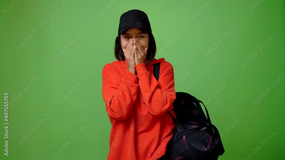 Woman with sport bag smiling a lot while covering mouth Woman with sport bag smiling a lot while covering mouth