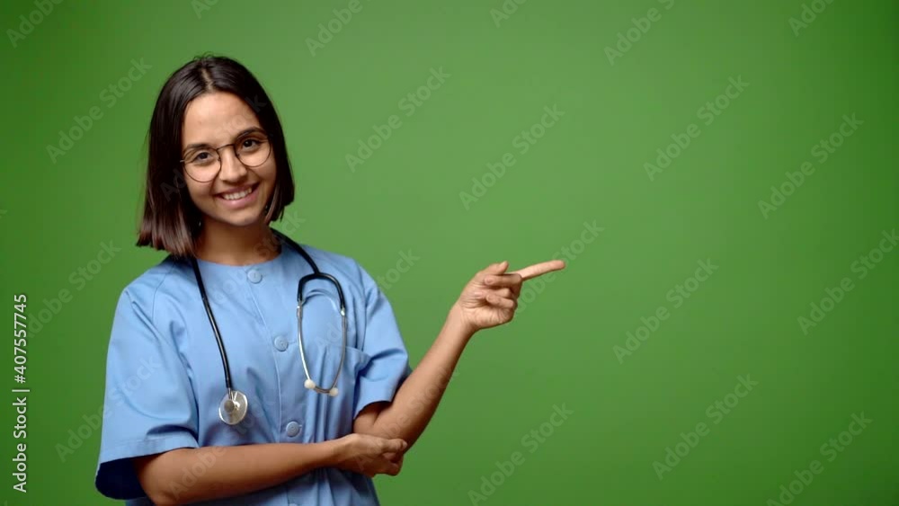 Woman with nurse uniform pointing finger to the side and presenting a product Woman with nurse uniform pointing finger to the side and presenting a product