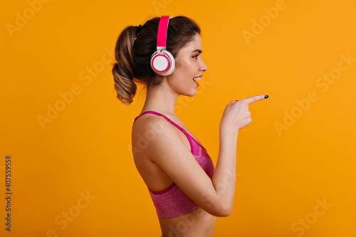 Fototapeta Naklejka Na Ścianę i Meble -  Lovely caucasian woman posing in headphones. Cheerful white girl enjoying sport exercises.