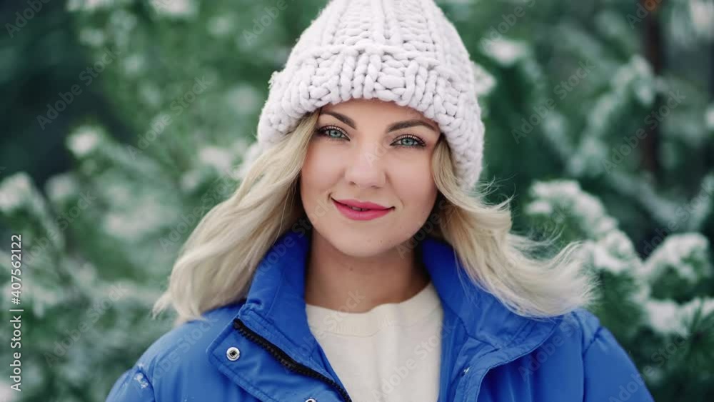 Attractive kind blonde girl smiling, lady in white knitted hat. Portrait of young pretty woman with perfect make-up and hairstyle in forest, winter season. Attractive kind blonde girl smiling, lady in white knitted hat. Portrait of young pretty woman with perfect make-up and hairstyle in forest, winter season.