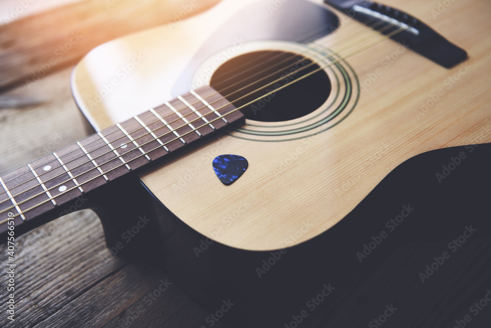 Guitar resting on old wooden background, Close up acoustic guitar and Guitar pick. Guitar resting on old wooden background, Close up acoustic guitar and Guitar pick.