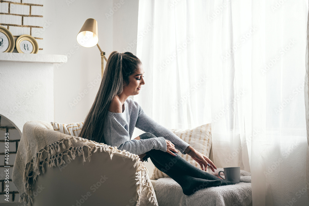 Retrato de una mujer hermosa y pensativa sentada en un sofá blanco ...