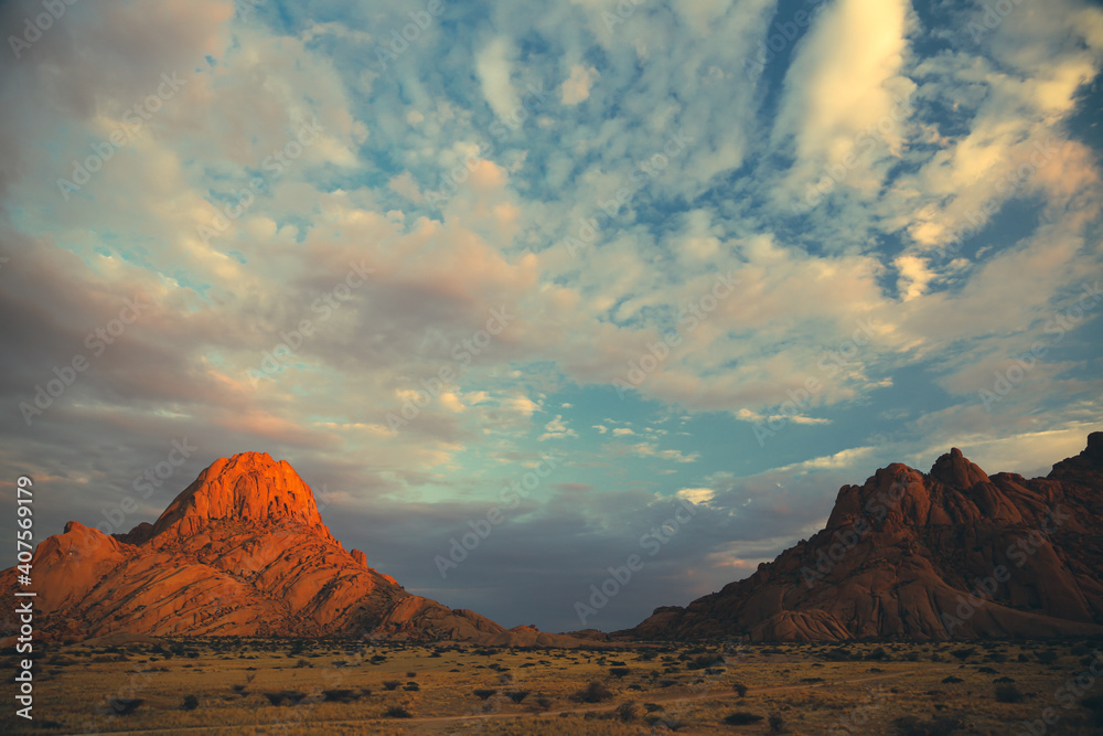 Fototapeta premium Illuminated mountain peaks at dusk in Spitzkoppe, Namibia