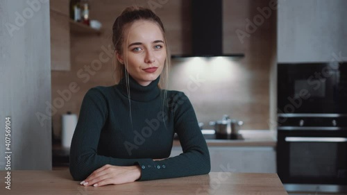 Attractive portrait of beautiful stylish young woman looking at camera on home smiling. Carefree confidence youth. At kitchen room. Slow motion