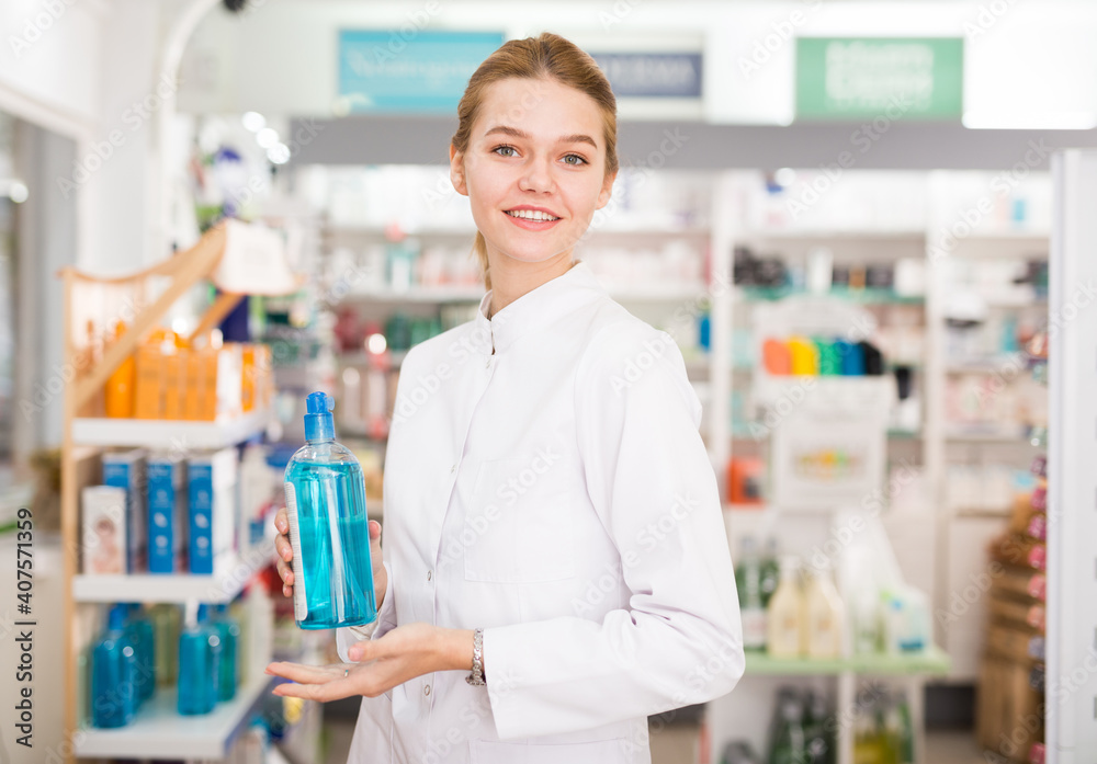 Smiling young pharmacist ready to assist in choosing at counter in pharmacy. High quality photo