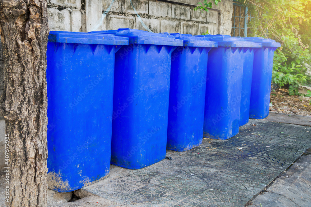 Many blue Trash cans in line on the side of the road. Many blue Trash cans in line on the side of the road.
