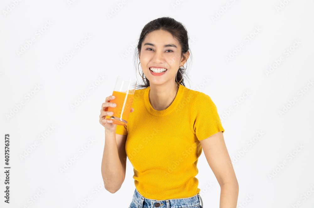 Smiling young Asian woman drinking orange juice over white isolated background. Lifestyle, Diet, Healthy and clean food concept. Smiling young Asian woman drinking orange juice over white isolated background. Lifestyle, Diet, Healthy and clean food concept.