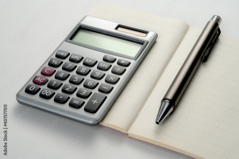 Top view of notebook with pen and calculator with white isolated background Top view of notebook with pen and calculator with white isolated background
