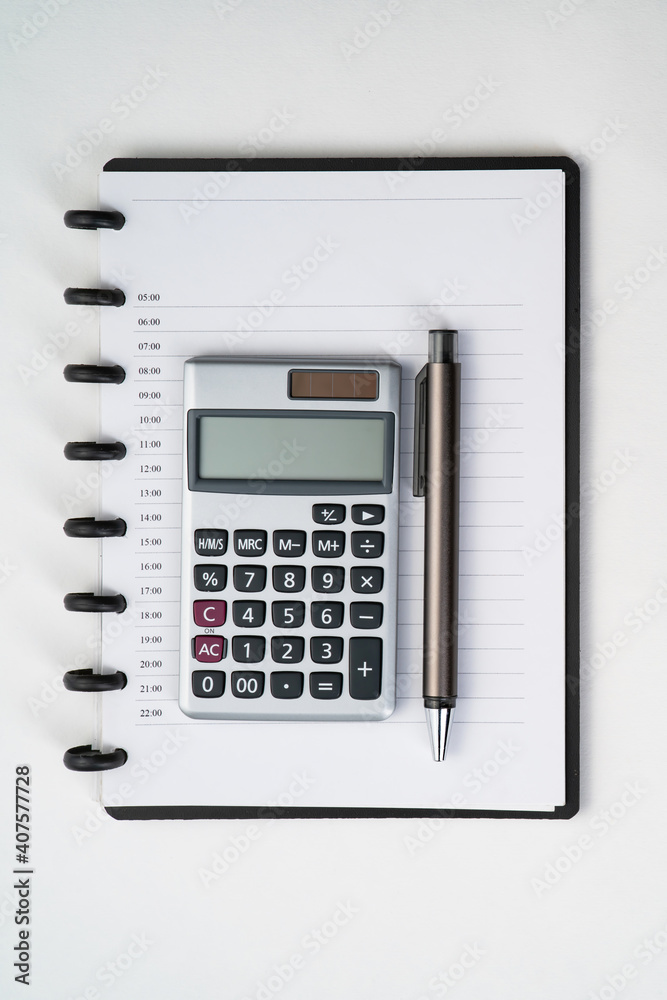 Top view of notebook with pen and calculator with white isolated background Top view of notebook with pen and calculator with white isolated background