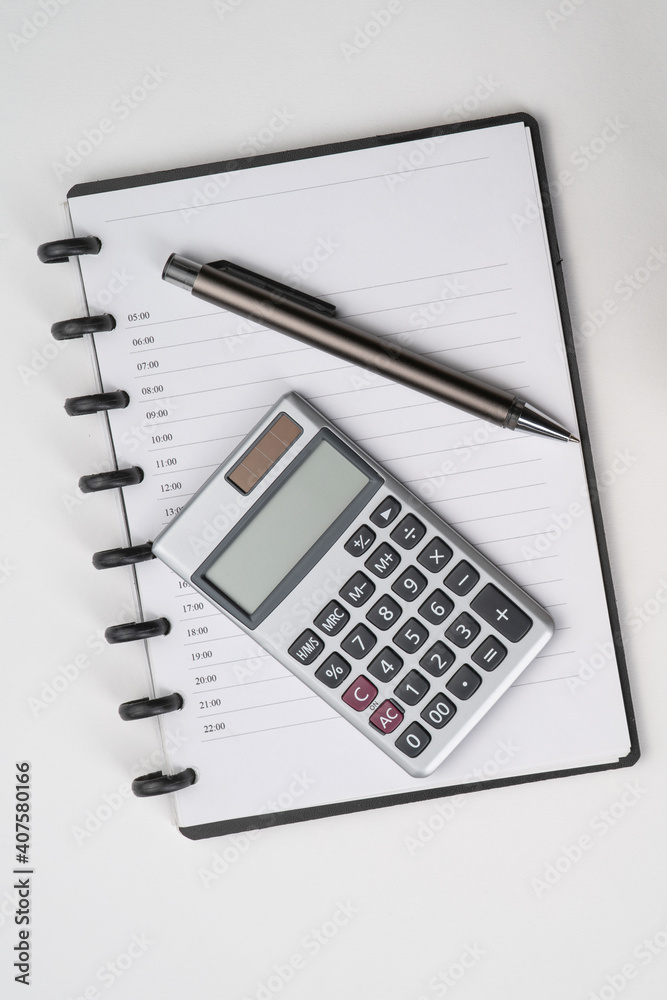 Top view of notebook with pen and calculator with white isolated background Top view of notebook with pen and calculator with white isolated background