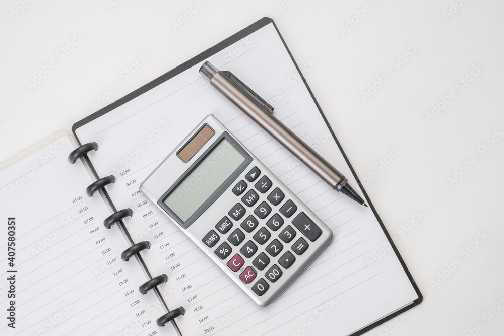Top view of notebook with pen and calculator with white isolated background Top view of notebook with pen and calculator with white isolated background