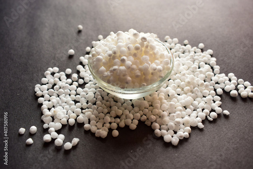 Pearls or white sago seeds balls in a Open Transparent Glass Bowl On isolated Black Background