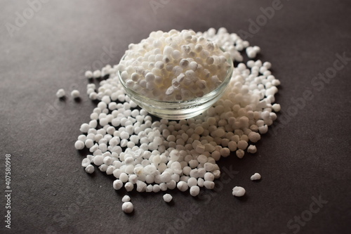 Pearls or white sago seeds balls in a Open Transparent Glass Bowl On isolated Black Background photo