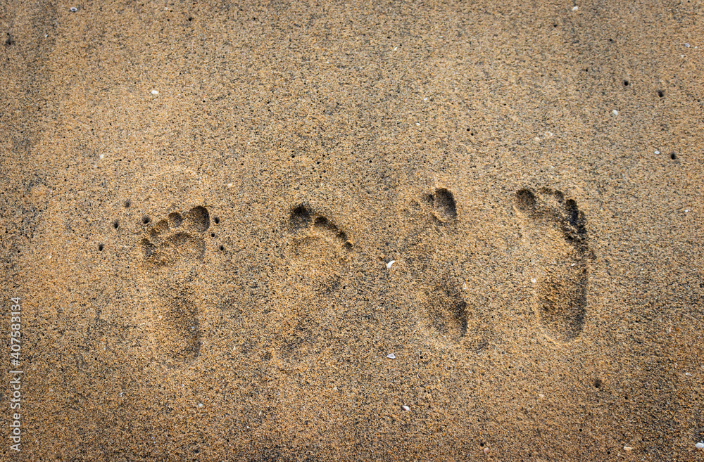 Couple footprint on yellow sand beach showing togetherness Couple footprint on yellow sand beach showing togetherness