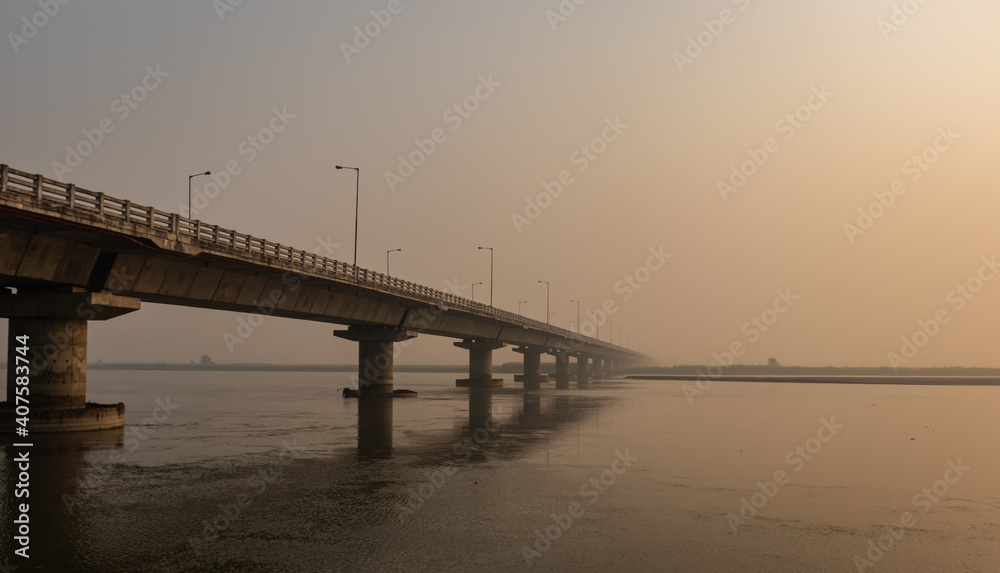 road bridge over river with its water reflection at dawn from low angle