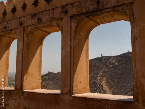 towers and fort walls on a hill frameed amber fort arches in jaipur