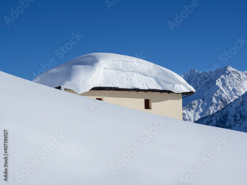 The roof of an house or hotel covered by massive quantity of fresh snow after heavy snowfall. Mountain and winter contest. Italian alps © Matteo Ceruti