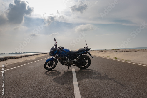 motorcycle isolated standing on tar road in sea shore background