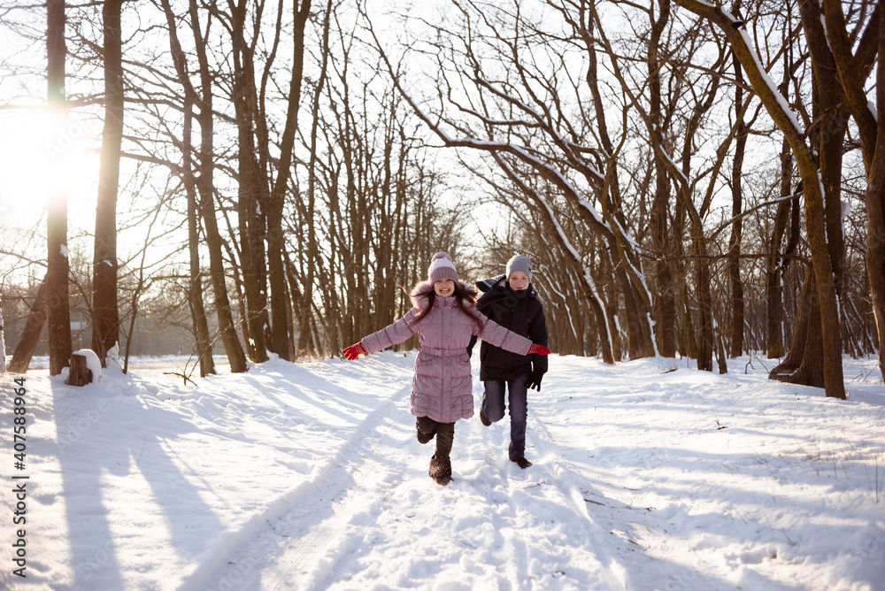 Brother and sister run through the snowy forest. Winter activities for children. Frost, snow and rest. Brother and sister run through the snowy forest. Winter activities for children. Frost, snow and rest.