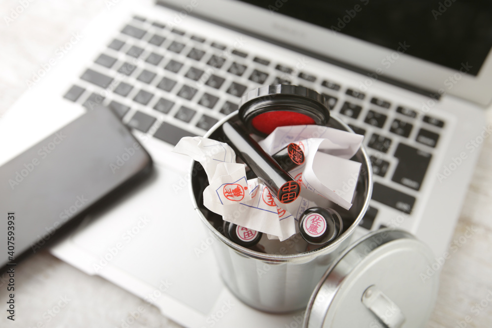 ノートパソコンとゴミ箱に入れた不要になった印鑑 Stock Photo Adobe Stock