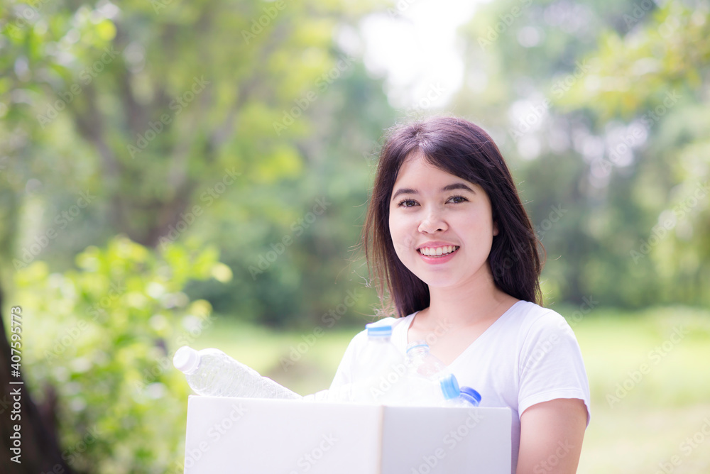 Asian Young woman hand picking up garbage plastic for cleaning at park.Environmental conservation. Asian Young woman hand picking up garbage plastic for cleaning at park.Environmental conservation.