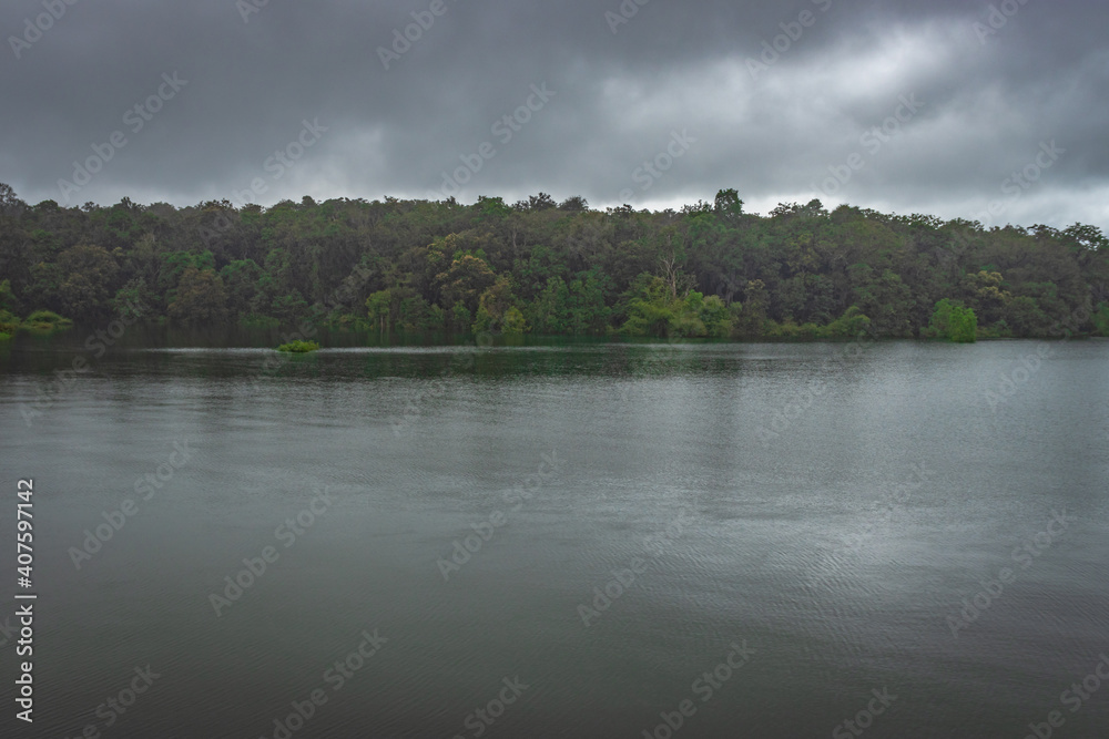 river serene back water with forests and dramatic cloudy sky