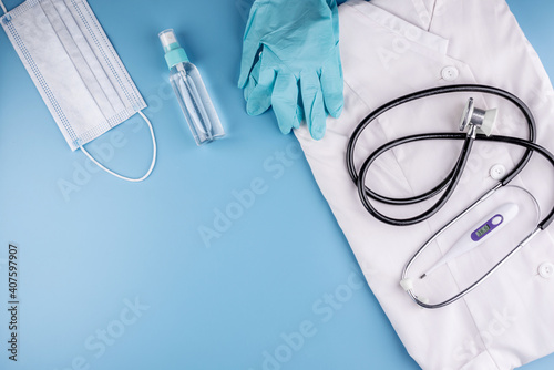 Tools and protective equipment for the doctor on a blue background. Top view and copy space