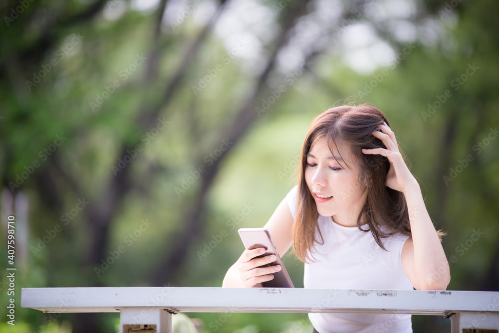 Beautiful Asian businesswoman uses a mobile phone to take a picture of herself while sipping coffee during a break to relax.