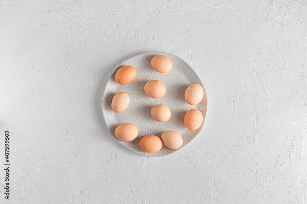 White plate or ceramic dish with raw eggs on light background White plate or ceramic dish with raw eggs on light background