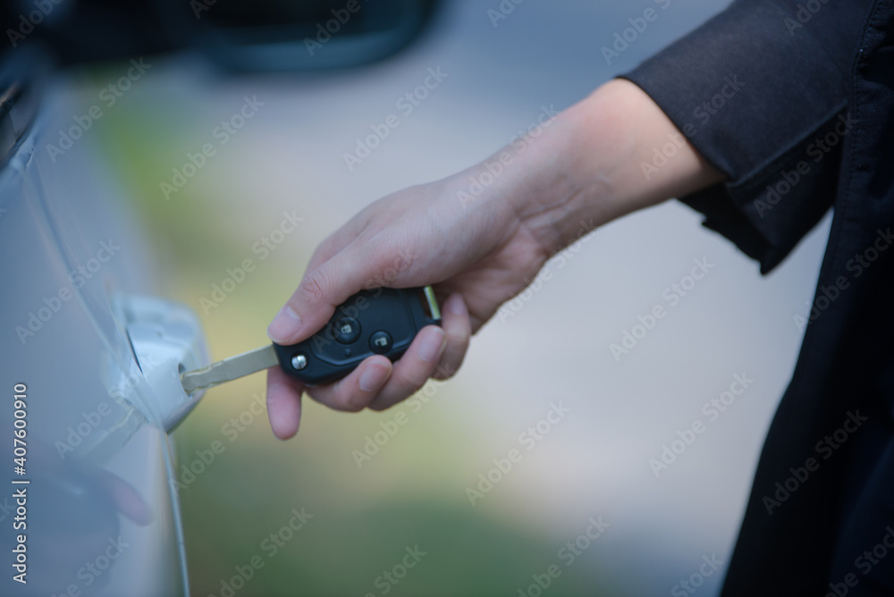 Asian woman sitting in a private car shows the keys in her hand.Selected focus