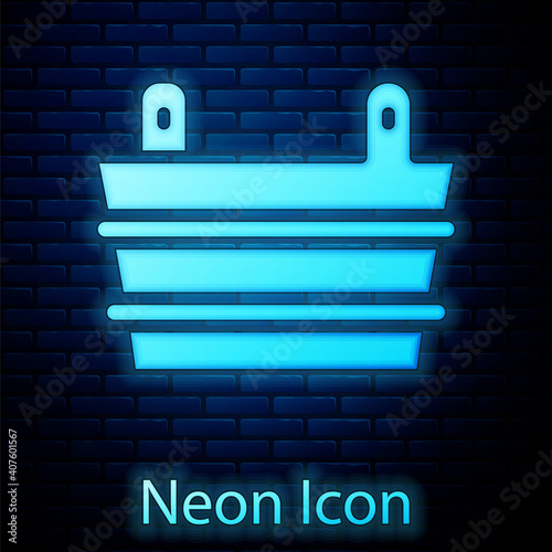 Glowing neon Sauna bucket icon isolated on brick wall background. Vector.