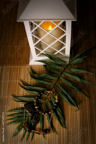 amber products on a leaf of a palm tree against the background of a white lantern, selective focus