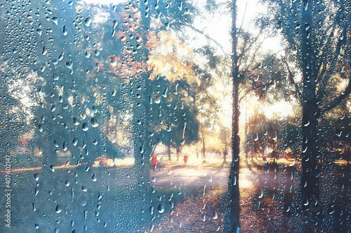 background wet glass drops autumn in the park / view of the landscape in the autumn park from a wet window, the concept of rainy weather on an autumn day © kichigin19
