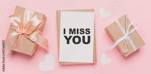 Gifts with note letter on isolated pink background, love and valentine concept with text I miss you