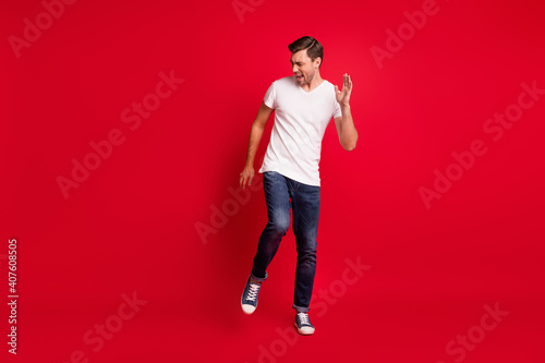 Full size photo of young satisfied man danceng open mouth shout yes isolated on dark red color background © deagreez